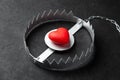 Trap with heart. Love is like bait. Black background. Royalty Free Stock Photo