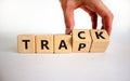 Trap or track symbol. Businessman turns wooden cubes and changes the word `trap` to `track`. Beautiful white background, copy