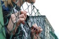 Young girl hand through green steel net close up Royalty Free Stock Photo