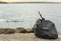 Trash bag full of garbage on beach. Space for text Royalty Free Stock Photo