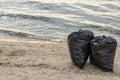 Trash bags full of garbage on beach. Space for text Royalty Free Stock Photo