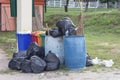 Trash bin and a black bag to hold garbage that overflows out.