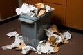 trash bin overflowed with crumbled paper