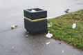 Trash bin and scattered trash on the grass in the park. Garbage collection and disposal, responsible consumption. Royalty Free Stock Photo