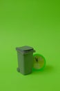 Trash can and a clock showing 5 minutes before 12 on a bright green background. Text space. Environmental protection concept. Royalty Free Stock Photo