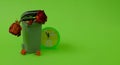 Trash can, dead flowers and a clock showing 5 minutes before 12 on a green background. Text space. Environmental protection. Royalty Free Stock Photo