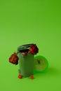 Trash can, dead flowers and a clock showing 5 minutes before 12 on a green background. Text space. Environmental protection. Royalty Free Stock Photo