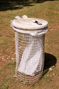 Trash can and recycling bin in park natural outdoor on sunny day. Garbage recycle can and trash bin with white plastic bag. Royalty Free Stock Photo