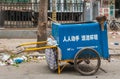 Trash collection push cart in street.