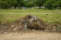 Trash and debris piled at an entrance to a park