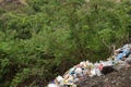 Trash garbage piles thrown along mountain side by uncaring and irresponsible neighborhood