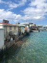 Trash and garbage in water behind dilapidated run down houses