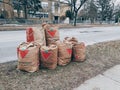 Trash litter collected in paper recycle bags from Canadian Tire store in piles on street