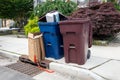 Trash and recycling bind on a curb with overflowing cardboard on trash pickup day Royalty Free Stock Photo