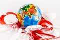 Trash scattered around globe on white Royalty Free Stock Photo