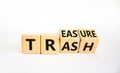 Trash to treasure symbol. Businessman turned cubes and changed the word trash to treasure. Beautiful white table, white background