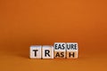 Trash to treasure symbol. Businessman turned cubes and changed the word trash to treasure. Beautiful orange table, orange