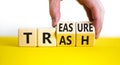 Trash to treasure symbol. Businessman turns cubes and changes the word trash to treasure. Beautiful yellow table, white background