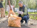 Trash, volunteer and elderly woman cleaning garbage, pollution or waste product for environment support. Plastic bag