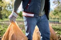 Trash, volunteer hands and man cleaning garbage, pollution or waste product for environment support. Plastic bag