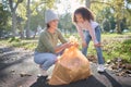 Trash, volunteer woman and kid cleaning garbage, pollution or waste product for environment community service. Plastic