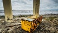 Trashed fridge into the lifeless sea, Caspian sea under blue sky in early September, snag on the beach, Rusty bridge on the beach