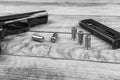 Traumatic pistol with bullets and cartridge on the wooden surface, black and white Royalty Free Stock Photo