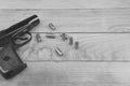 Traumatic pistol with bullets and cartridge on the wooden surface, black and white Royalty Free Stock Photo