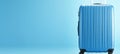 Travel accessories on blue background studio shot for advertising with empty suitcase