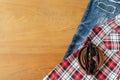 travel accessories and costume on wood floor, jean, shirt, belt, sun glassses