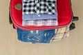 travel accessories and costume on wood floor, jean, shirt, suitcase Royalty Free Stock Photo