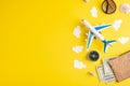 Travel accessories and items on a yellow background with a top view and copy space. Toy airplane in the clouds and a passport, Royalty Free Stock Photo