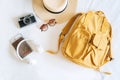 Travel accessories with straw hat, sunglasses, bagpack, camera, headphone and passport on bed in hotel room. Travel, relaxation,