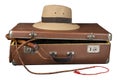 Travel and adventure concept. Vintage brown suitcase with fedora hat and bullwhip isolated on white