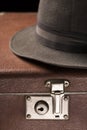 Travel and adventure concept. Vintage brown suitcase with vintage hat on black background Royalty Free Stock Photo
