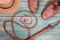 Travel and adventure concept. Vintage fedora hat, bullwhip and old brown shoes on green wooden table. Top view. Royalty Free Stock Photo