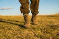 Travel adventure. future. military shoes. male feet in green boots. hynter searching for victim in grass field. going to Royalty Free Stock Photo