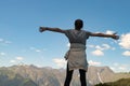 Travel, adventure and trekking by Hiking in the mountains. A girl stands on top of a mountain hands up Royalty Free Stock Photo