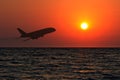 Travel agency, international flights, hotel and air tickets booking, silhouette of an airplane taking off at sunset on sky Royalty Free Stock Photo