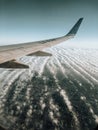 Aerial wing airplane. Views through the window of an airplane. Cloudy light blue sky. Concept of travel, holidays and vacations.