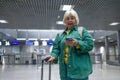 Travel, airport senior 60s woman in comfy casual outfit going vacation alone, holding a smartphone and booking cheap Royalty Free Stock Photo
