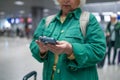 Travel, airport senior 60s woman in comfy casual outfit going vacation alone, holding a smartphone and booking cheap Royalty Free Stock Photo