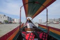 Travel along the Chao Phraya River on a long tourist boat. The driver is sitting in front and talking on phone