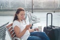 Travel app, woman using mobile smart phone in airport, passenger waiting in gate terminal Royalty Free Stock Photo