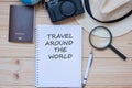 Travel around the Word word on notebook with accessories, Camera, Passport, Magnifying,and hat on wooden table, Top view and copy