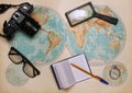 Old map of the hemispheres on it a camera, clock, magnifier and a notebook Royalty Free Stock Photo