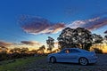 Travelling in Australian countryside with car by sunset sky, HDR