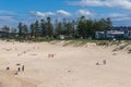 Travel background of picturesque sandy beach with incidental people