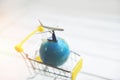 Travel background and shopping concept - Airplane Traveler`s fly Airlines worldwide with plane world globe on shopping cart