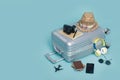 Travel Baggage with passport, camera, hat, wallet, airplane toy and smartphone isolated on blue background with copy space, Travel